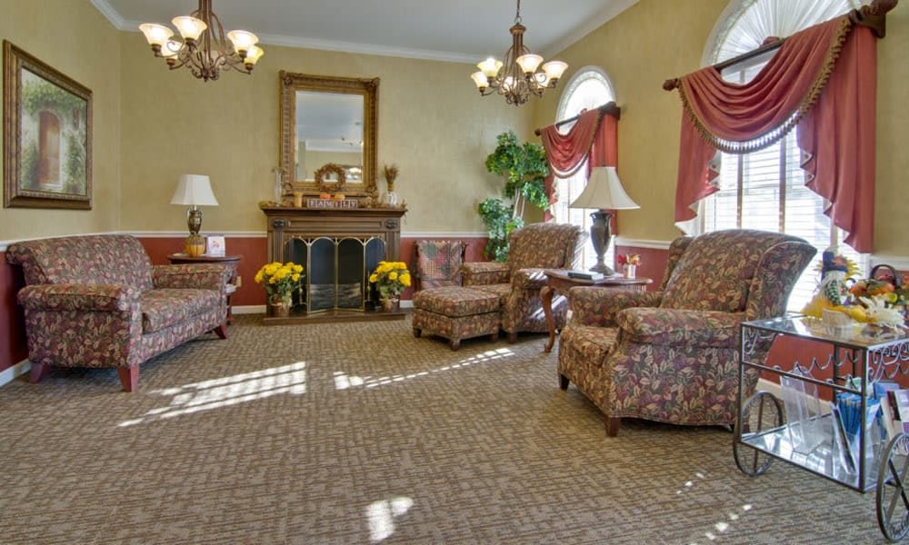 A traditional living room featuring a fireplace, armchairs, and elegant decor.