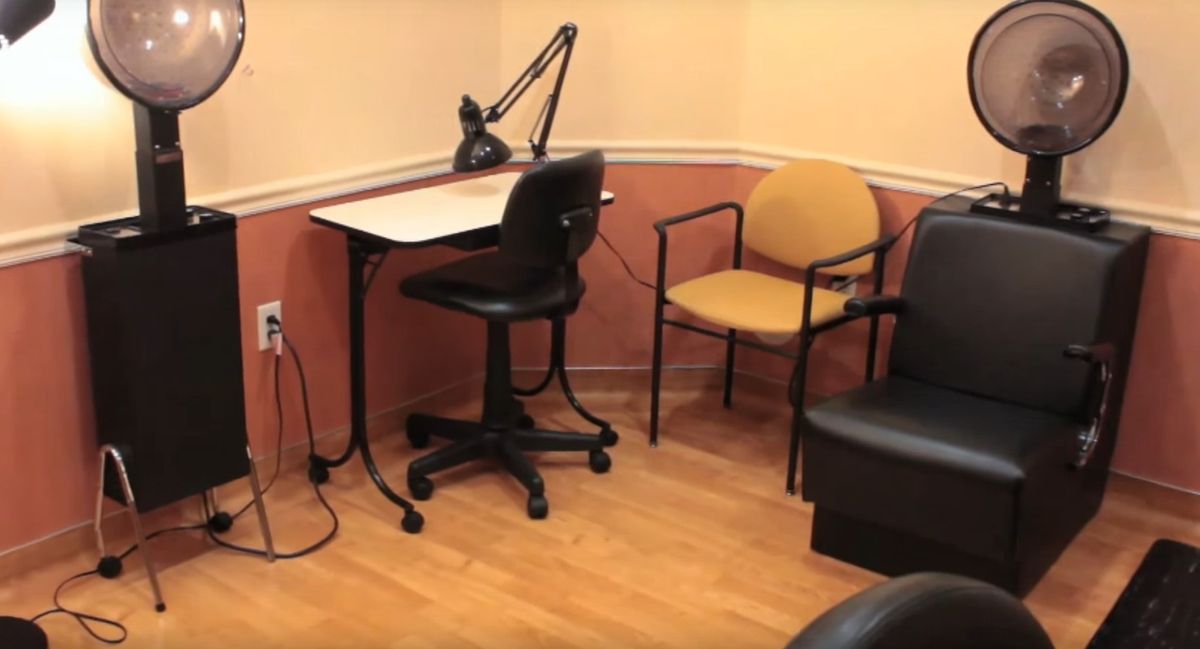 A small office space with a desk, chair, and lamp.