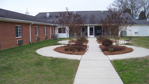 A welcoming entrance to a building surrounded by landscaped gardens.