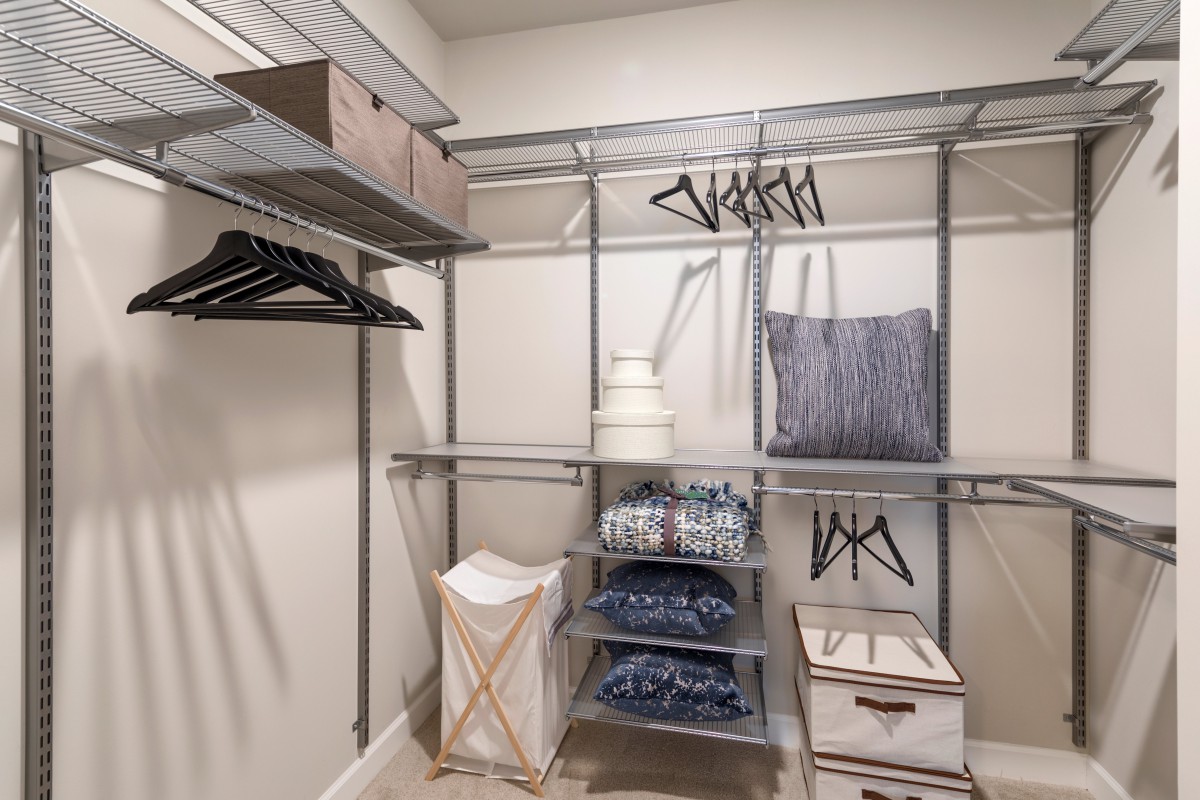 A neatly organized closet with shelves, hangers, and storage baskets.