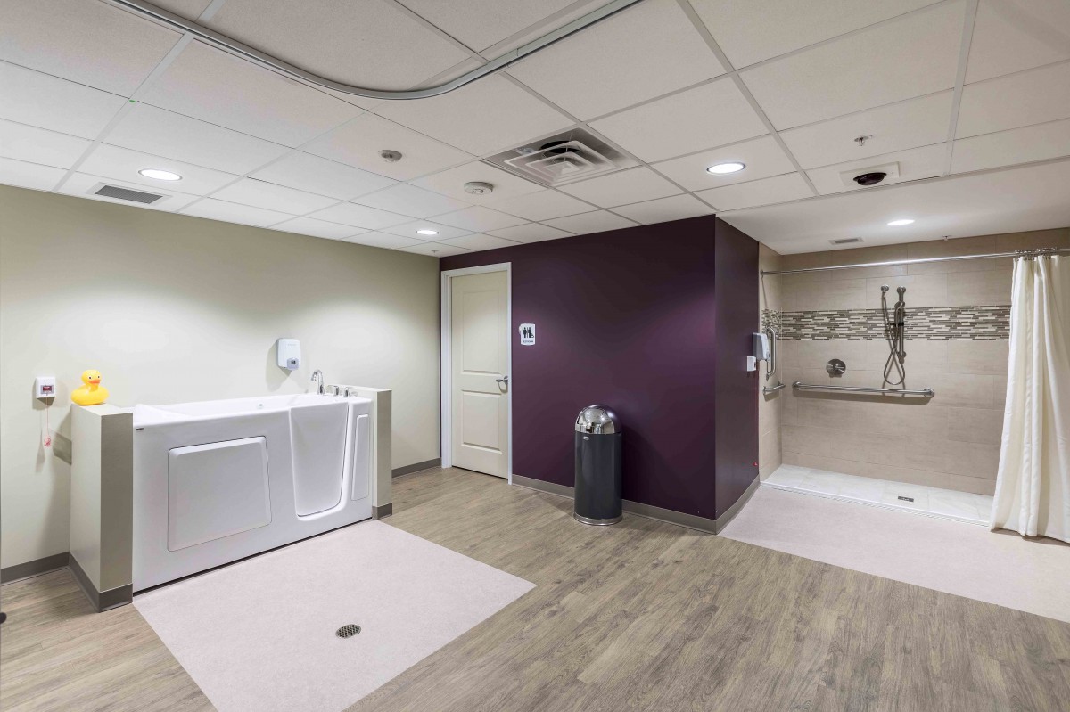 A spacious, modern bathroom in a healthcare facility with accessible features.