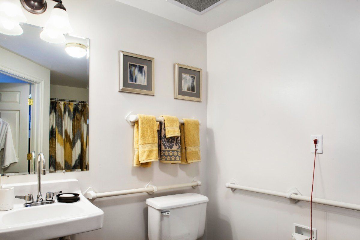 A neatly arranged bathroom featuring decorative towels and framed wall art.