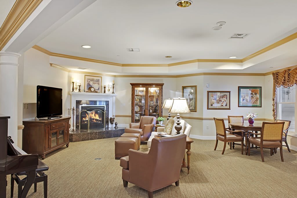 A cozy living room with a seating area arranged around a fireplace.