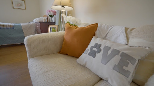 A cozy corner of a living room featuring decorative pillows and a lamp.