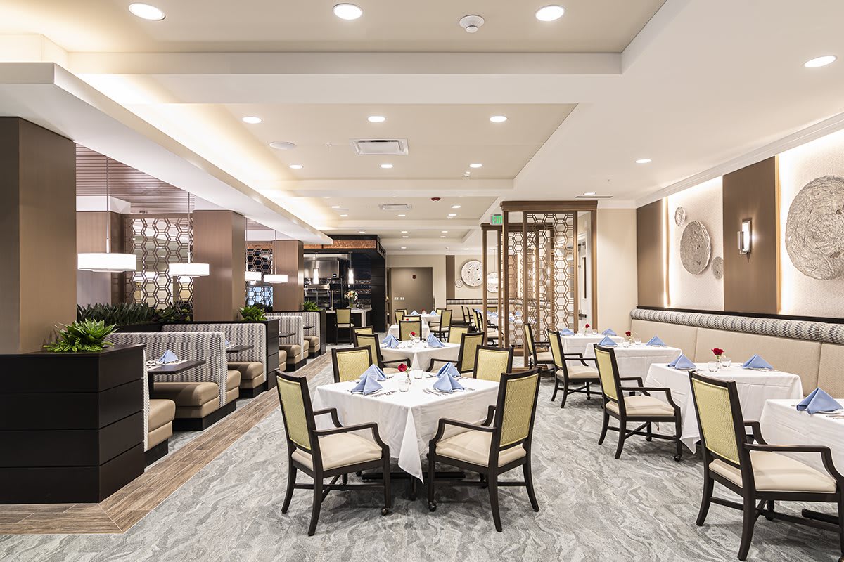 A modern and elegant restaurant interior featuring well-arranged tables and chairs.