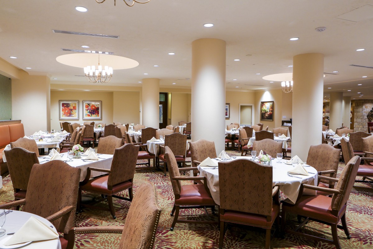 An elegant restaurant dining room with neatly arranged tables and chairs, ready for guests.