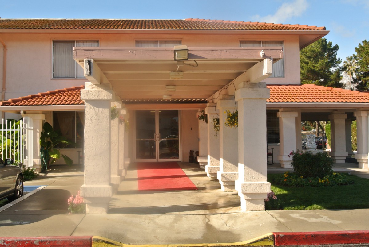 A grand entrance of a building with columns and a red carpet.