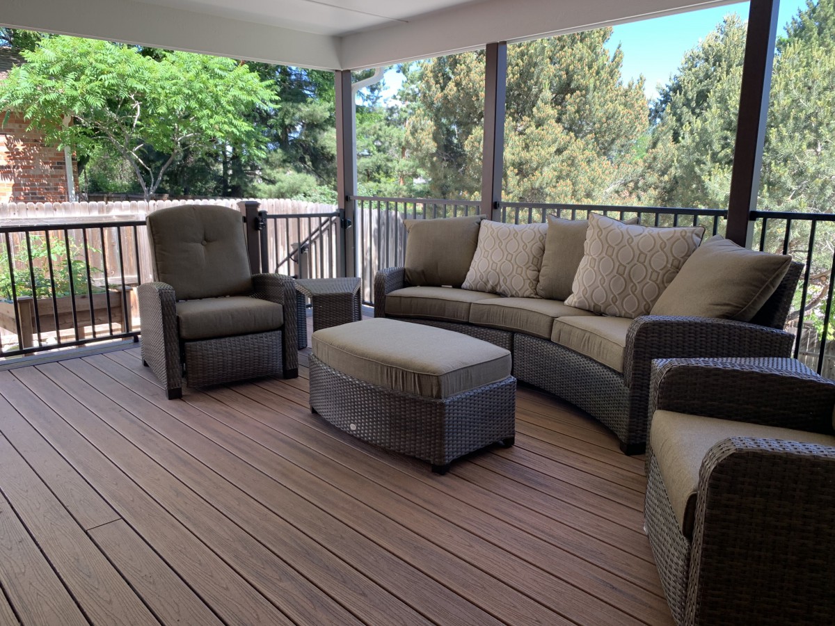 A cozy outdoor patio with cushioned seating and wooden flooring, perfect for relaxation.