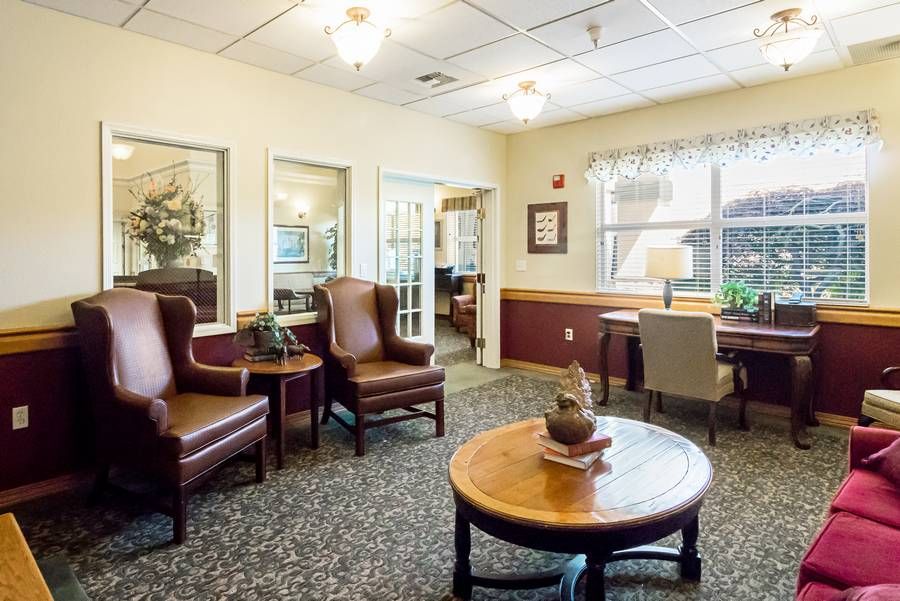A cozy living area featuring comfortable chairs, a round table, and tasteful decor.