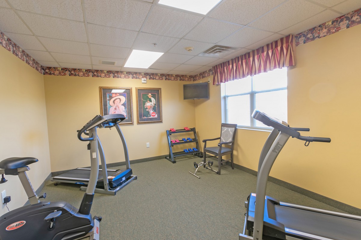 A small fitness room equipped with treadmills and decorative artwork on the walls.