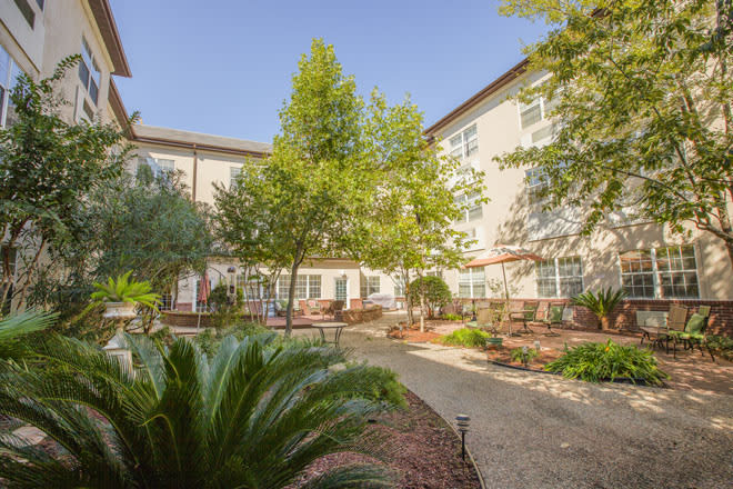 A serene courtyard with lush greenery and comfortable outdoor seating.