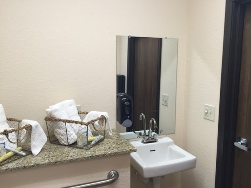 A clean and minimalist bathroom setup featuring a sink, mirror, and neatly arranged towels.