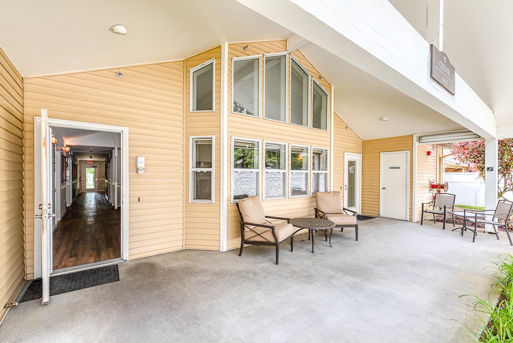A cozy outdoor patio area with chairs and a table against a building exterior.