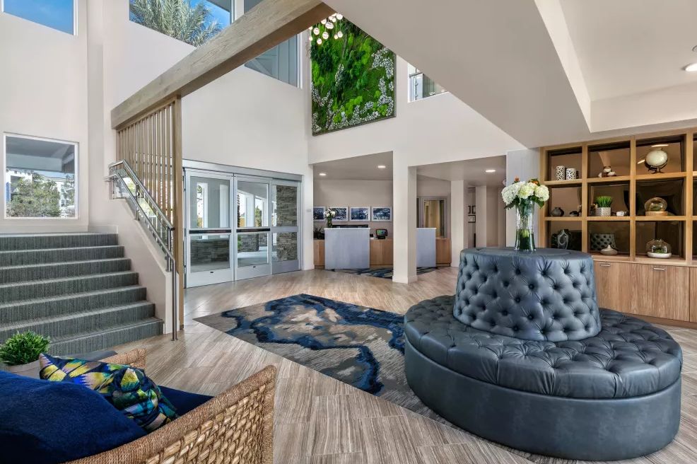 A modern lobby area featuring elegant furniture and a stylish staircase.