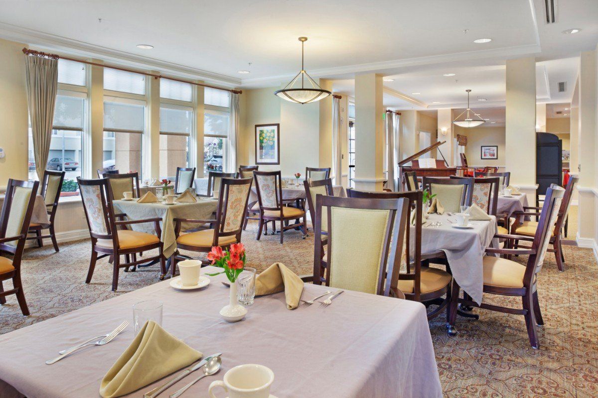 A formal dining room with neatly arranged tables and chairs, showcasing an elegant interior design.