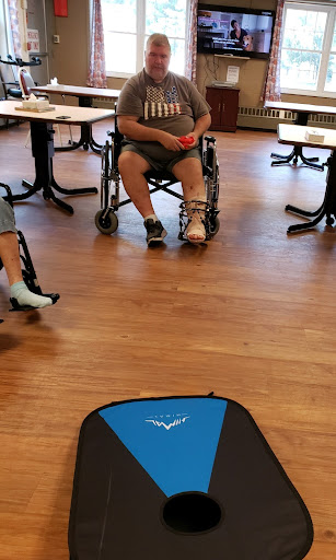 Participants engage in an activity while seated in wheelchairs within a community space.