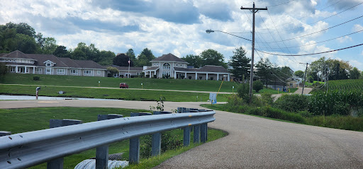 A view of a building from a winding road under a cloudy sky.