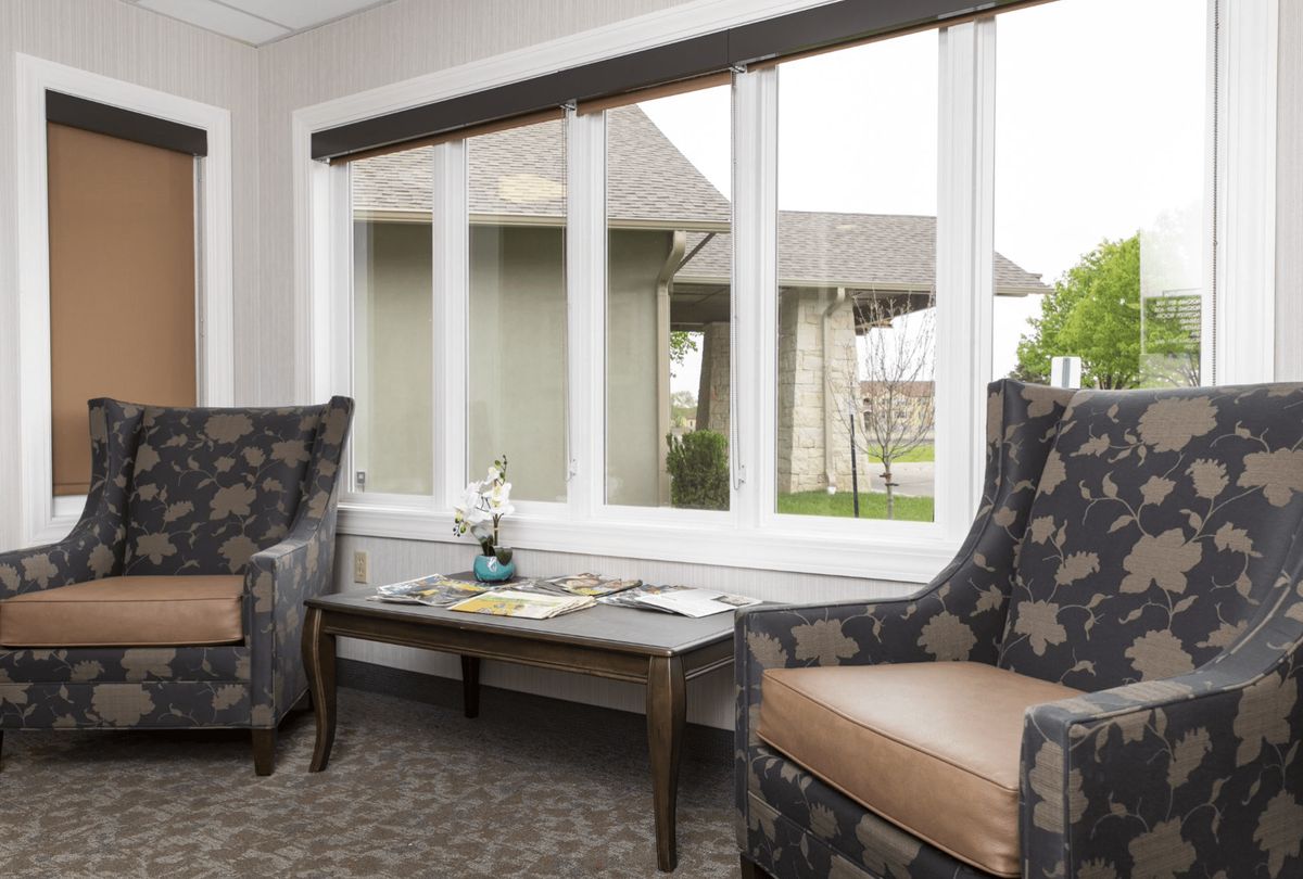 Cozy living room with chairs and a table by the window.
