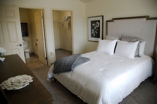 A cozy and minimalistic bedroom featuring a neatly made bed and soft decor.