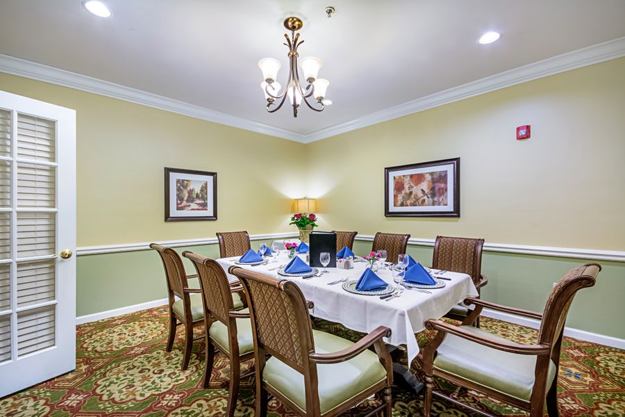 An elegantly set dining room with a chandelier and wall art.