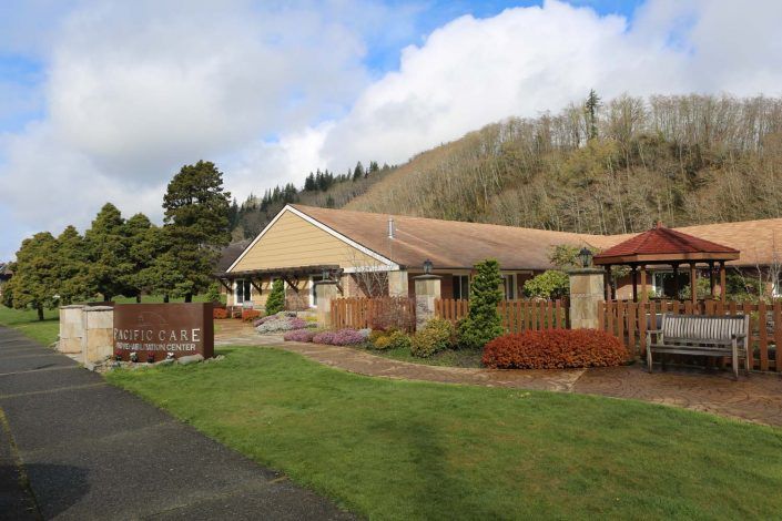 A peaceful residential house surrounded by a well-maintained garden and trees under a partly cloudy sky.