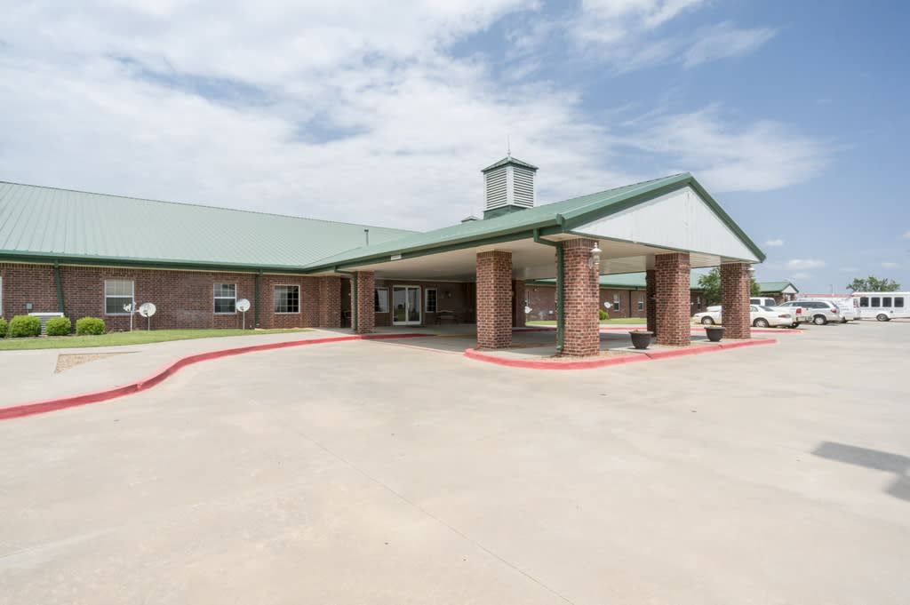 A brick building with a covered entrance and clear skies above.