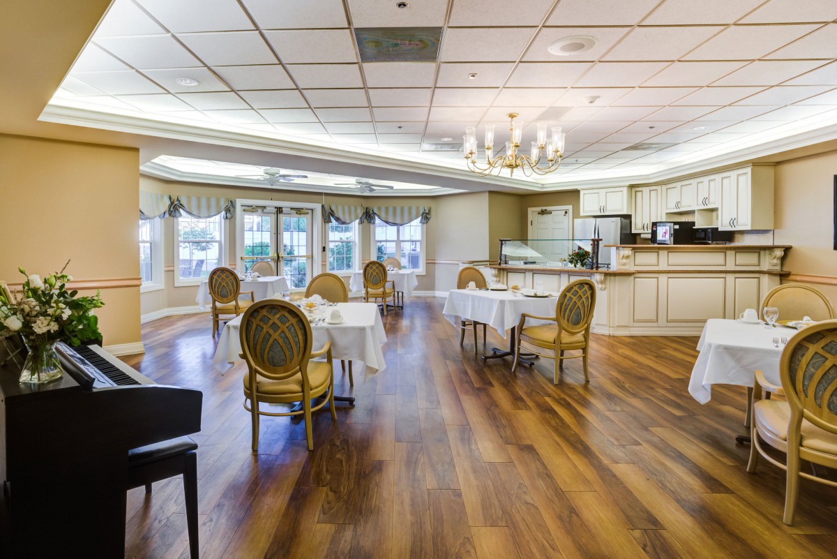 A spacious dining room with elegant furniture and a warm wooden floor.