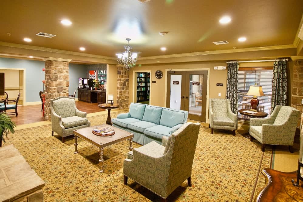 A cozy living room with comfortable seating, a chandelier, and warm lighting.