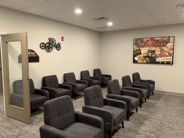A small indoor theater with rows of comfortable seating and movie-themed decor.