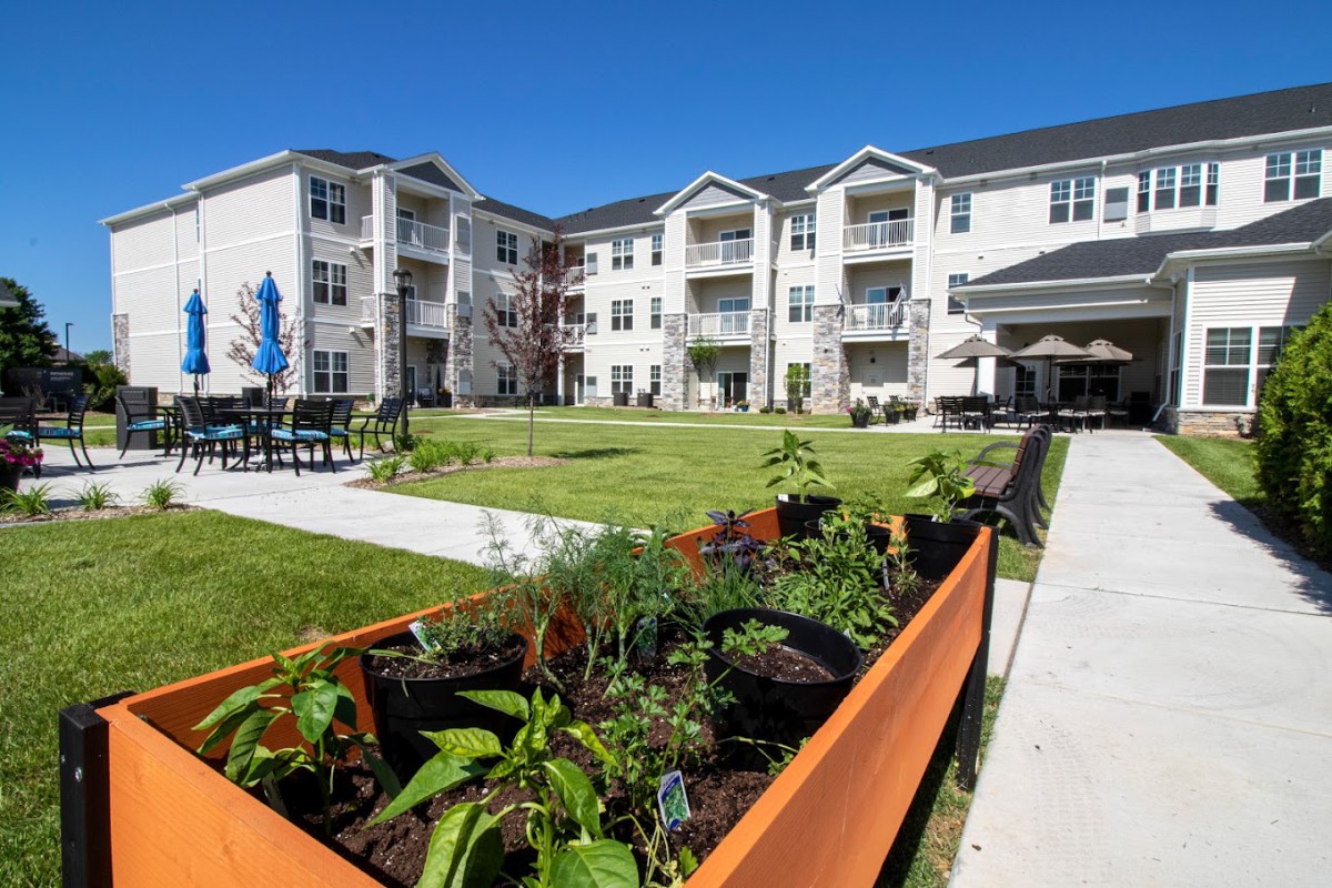 A modern residential complex with a landscaped garden area and outdoor seating.