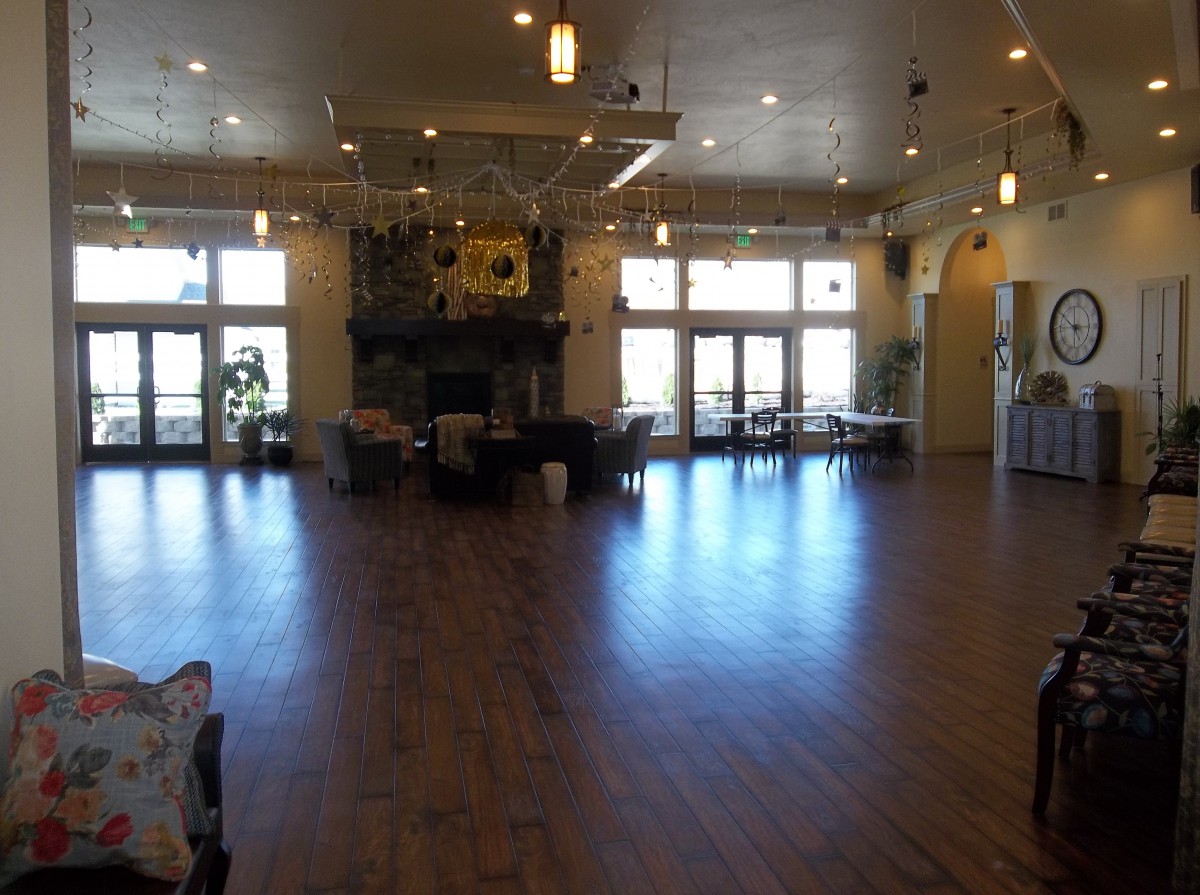 Spacious hall with wooden flooring and large windows.