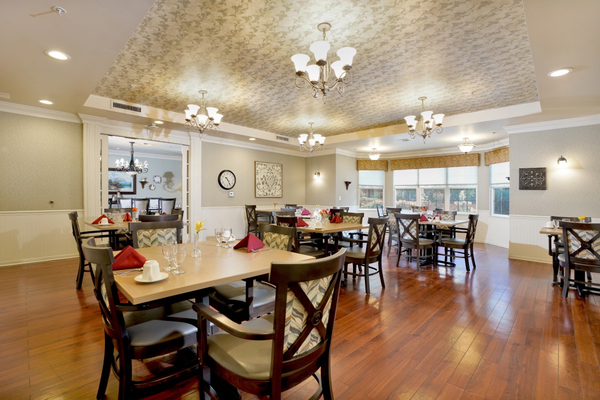 An elegantly decorated dining room with neatly arranged tables and chandeliers.