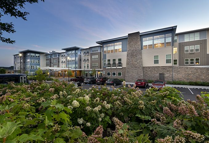 Modern building surrounded by greenery in the evening light.