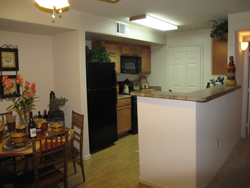 A cozy kitchen with a dining area, featuring wooden cabinets and modern appliances.
