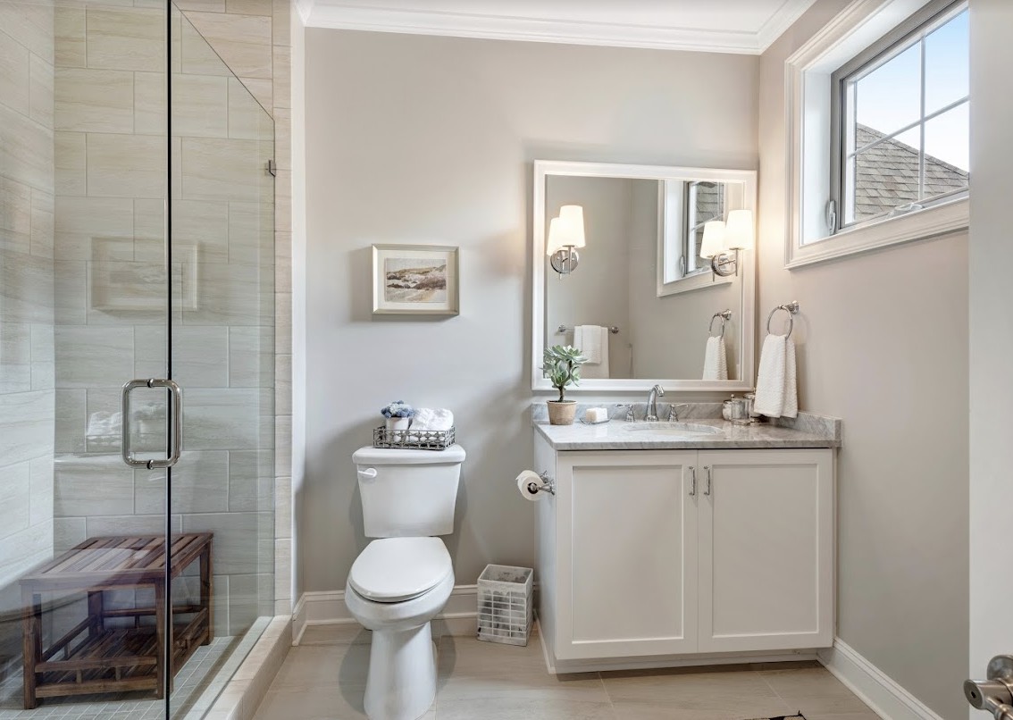 A modern and clean bathroom with a shower, sink, and toilet.
