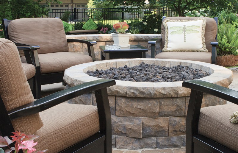 Cozy outdoor seating area with a central fire pit surrounded by comfortable patio chairs.