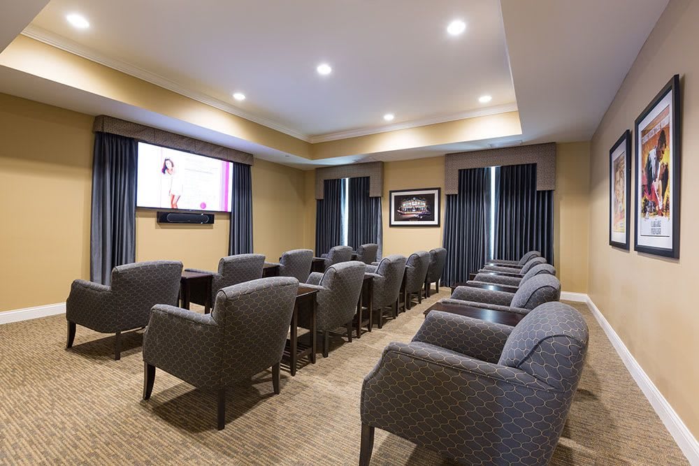 A cozy home theater with rows of comfortable seating and a large screen.