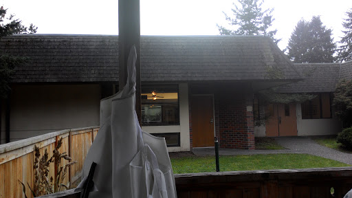 A view of a house with a cloudy sky in the background.