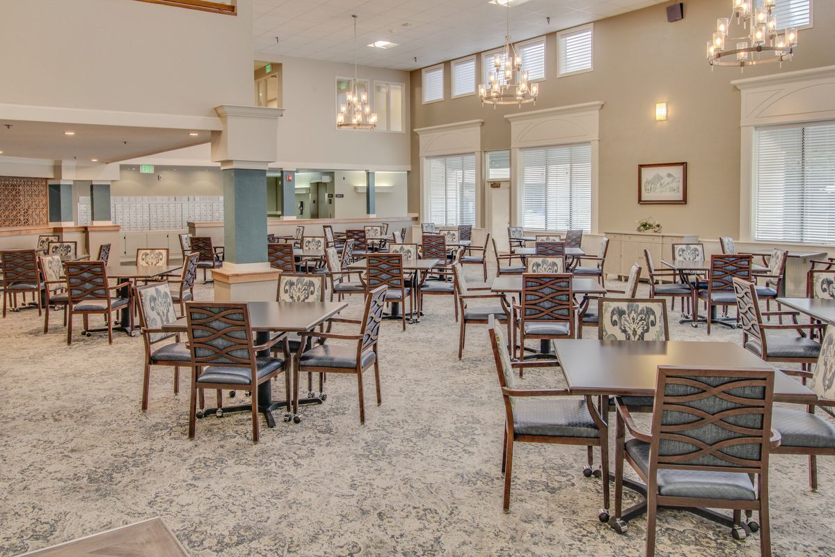 A spacious and well-lit dining area with neatly arranged tables and chairs.