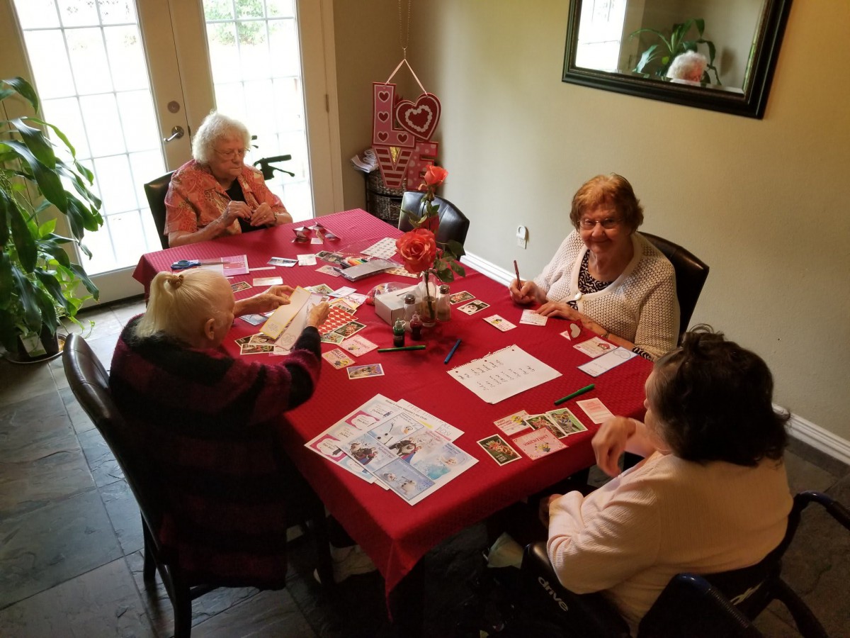 A group of seniors enjoying a card game at a table indoors.