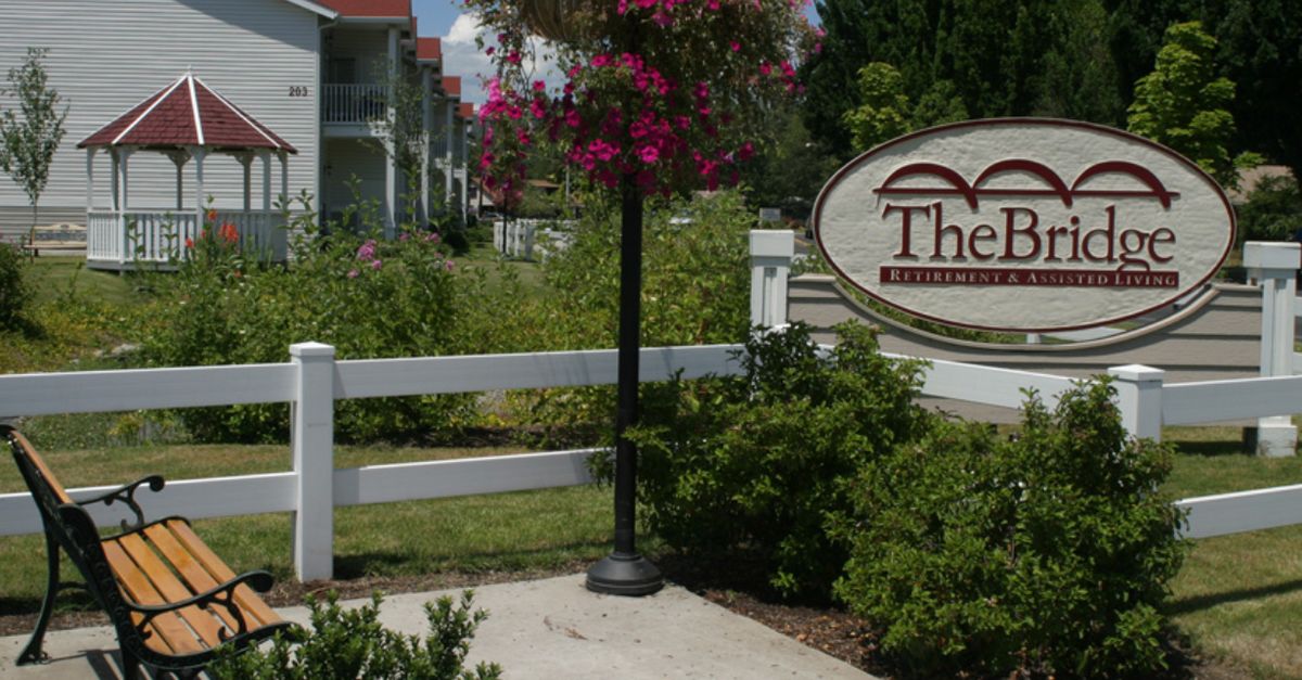 A landscaped garden area with a sign and flowering plants.