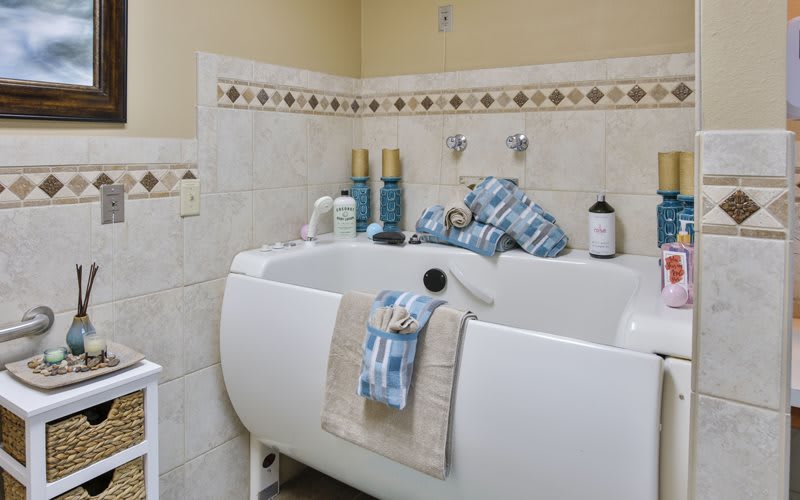 A tidy bathroom featuring a bathtub with neatly arranged towels and hygiene products.
