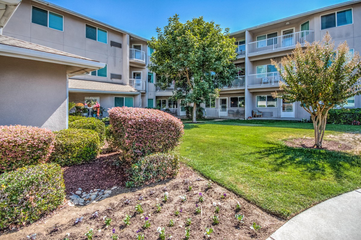 A well-maintained apartment complex with landscaped lawns and shrubs.