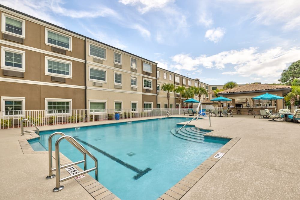 An outdoor swimming pool at a hotel with surrounding facilities.