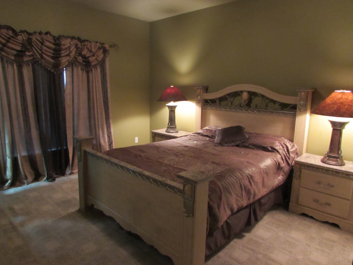 A cozy bedroom with a large wooden bed and matching nightstands.