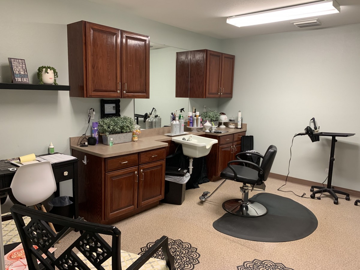 A well-equipped hair salon with styling stations, chairs, and various beauty products.