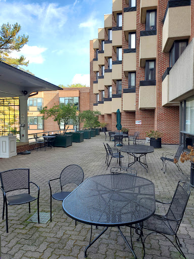 A serene outdoor patio area with tables and chairs, surrounded by a modern building.