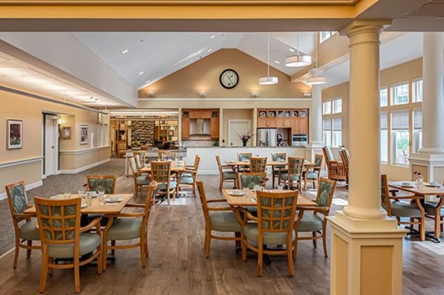 A cozy and inviting dining area with neatly arranged tables and chairs, featuring warm lighting and elegant decor.