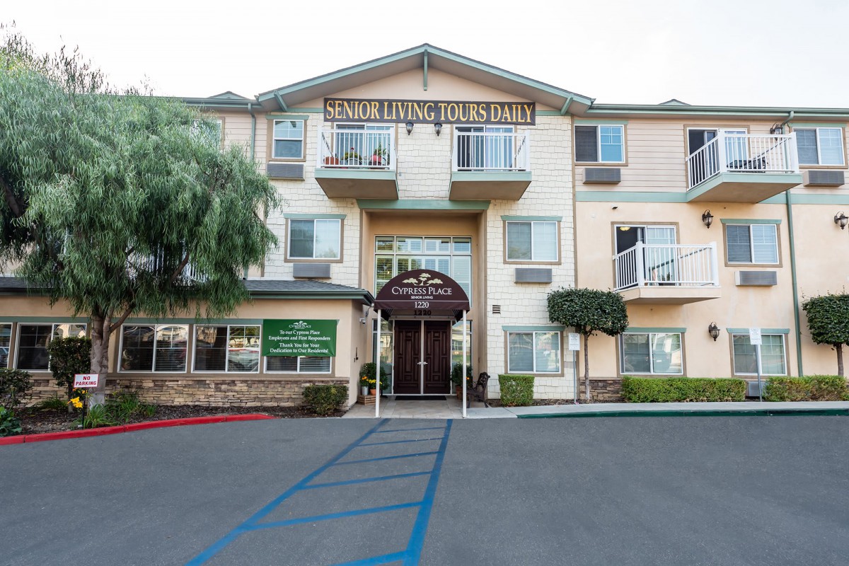 The entrance of a hotel building with multiple floors and a covered entryway.