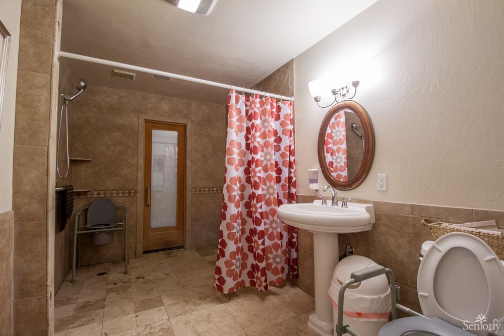 A cozy bathroom with a floral shower curtain and elegant fixtures.